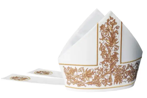 Biała mitra z bogatymi złotymi haftami, symbol godności duchownego.