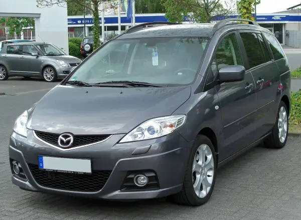 Szary minivan Mazda 5 na parkingu. Wiele osób szuka mazda 5 opinie, ten model jest dobrym wyborem.