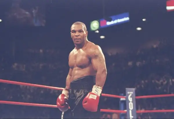 Mike Tyson in the ring, ready to fight. His intense gaze hints at the dedication required to train, making one wonder how long did Mike Tyson train a day to achieve such power.
