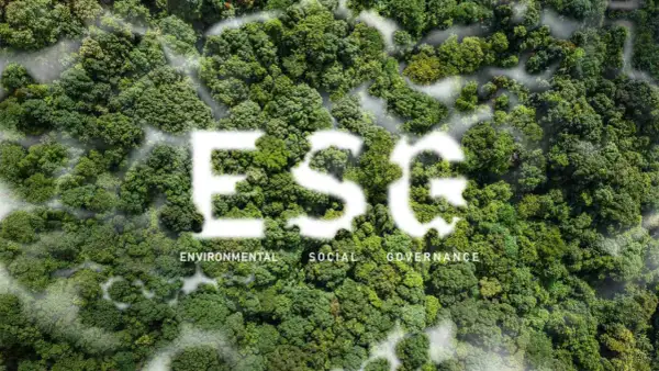 Foresta lussureggiante con la scritta "ESG" in bianco, che simboleggia investimenti ESG. Sotto, le parole "Environmental, Social, Governance".