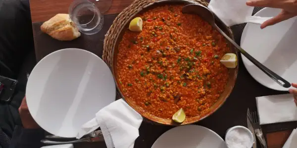 Paella mixta, un clásico que no puede faltar si te preguntas qué comer en Cabo de Gata. Servida en una paellera, con limón y pan.