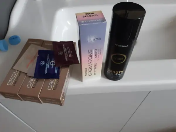 Butelka serum Montibello Smooth Sleek Serum, pudełko z tonerem do włosów Cromatone i próbki kosmetyków.