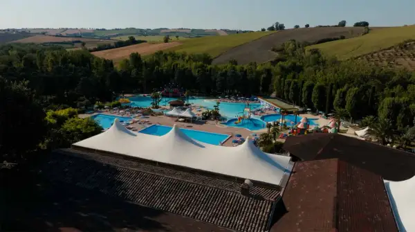 Vasta area con piscine, scivoli e aree relax nel parco acquatico di Cingoli, immerso nel verde delle colline marchigiane.