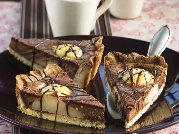 Drei Stücke saftiger Birnen Schoko Kuchen auf einem Teller, verziert mit Schokoladenglasur und Birnenstücken.