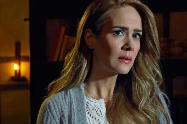 Sarah Paulson w filmach, serialach i programach, z zapaloną świecą w tle.