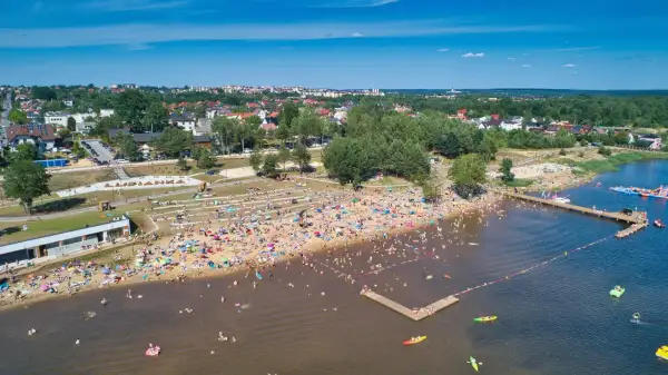 Tłoczna plaża nad zalewem w Starachowicach, pełna ludzi kąpiących się i opalających. Idealne starachowice atrakcje dla dzieci i dorosłych w słoneczny dzień.