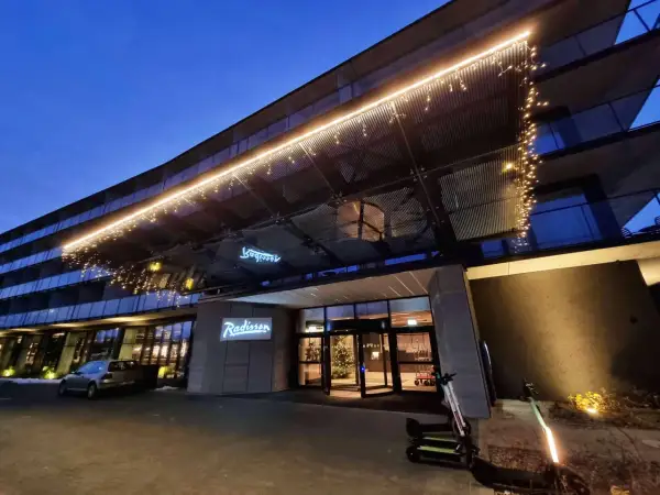 Wejście do hotelu Radisson Resort Kołobrzeg nocą, ozdobione lampkami.