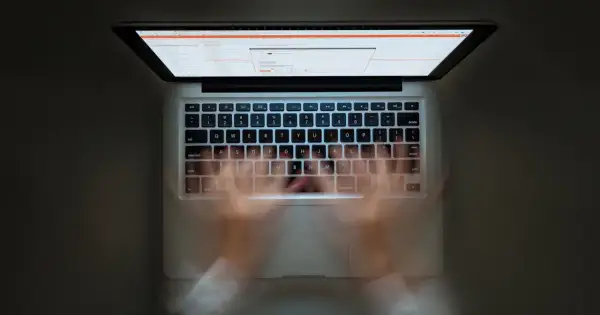 Ręce szybko piszą na klawiaturze laptopa. Widać ekran z kodem. Szybkie pisanie to jak zaznacz wszystko skrót.