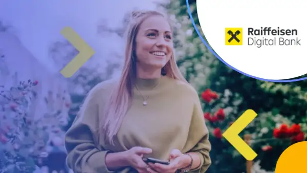 Uśmiechnięta kobieta z telefonem w ręku, korzystająca z usług Raiffeisen Digital Bank.