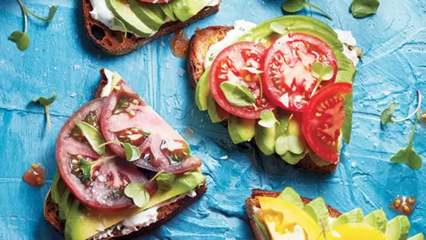 Tartines gourmandes : une recette avocat simple et savoureuse avec tomates fraîches et pousses croquantes sur pain grillé.