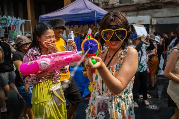 Tajlandia ludność bawi się na festiwalu Songkran, strzelając do siebie z pistoletów na wodę.