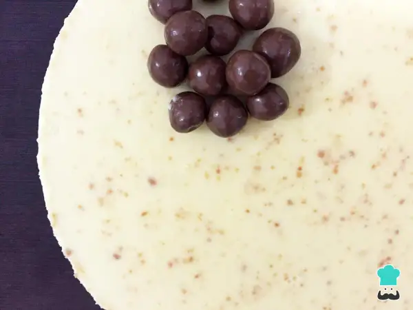 Deliciosa tarta de chocolate blanco, cubierta con crujientes bolitas de chocolate oscuro. ¡Un postre irresistible!