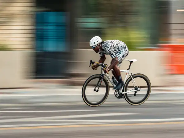 Dynamic racing photography captures a cyclist in motion, blurring the background to emphasize speed.