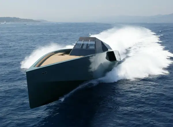 Un elegante yacht, forse quello di Gianluca Vacchi, sfreccia sull'acqua blu, lasciando una scia bianca.