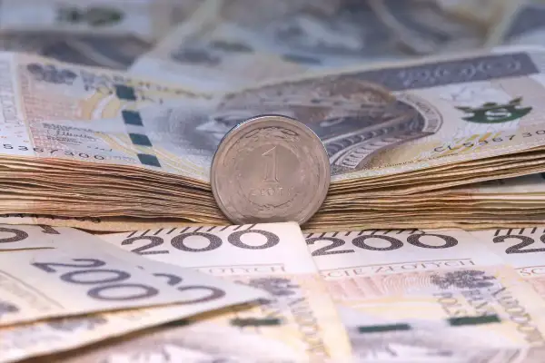 Stos banknotów 200 zł i 100 zł, z monetą 1 zł na wierzchu. Symbolizuje to wynagrodzenie młodocianych, które może być niewielkie na początku kariery.