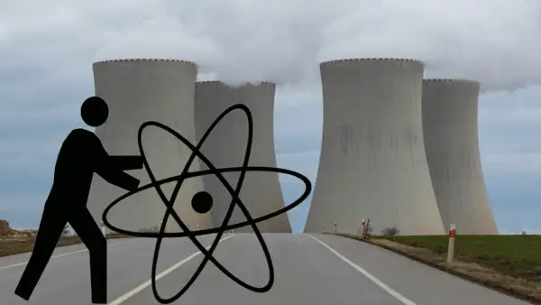 Człowiek z atomem przed chłodniami kominowymi elektrowni jądrowej symbolizuje potencjalne wady elektrowni jądrowej.