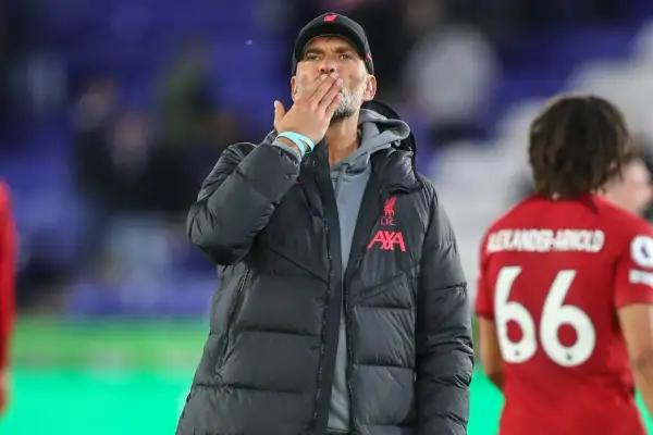 Trener Liverpoolu, Jürgen Klopp, posyła całusa kibicom. Obok niego stoi piłkarz z numerem 66.