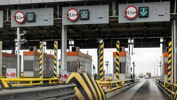 Płatne autostrady w Polsce: szlabany na bramkach poboru opłat, znaki ograniczenia wysokości 2,0m i zielone strzałki wskazujące otwarte pasy ruchu.