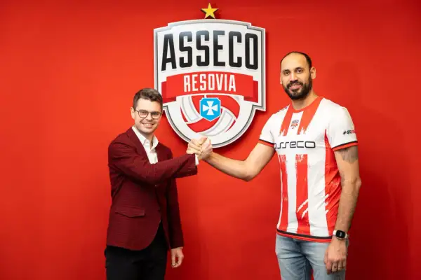 Mauricio Borges w koszulce Asseco Resovii ściska dłoń z mężczyzną w garniturze.