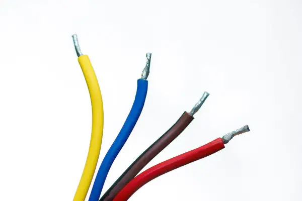 Quatre fils électriques dénudés : un jaune, un bleu, un fil bleu et marron, et un rouge, sur fond blanc.