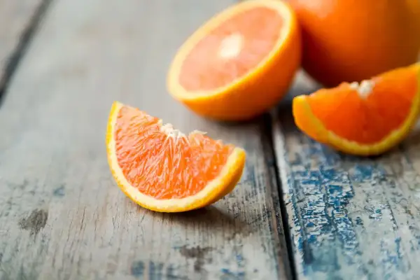Arance fresche tagliate a spicchi su un tavolo di legno. Quante arance si possono mangiare al giorno per un pieno di vitamina C?