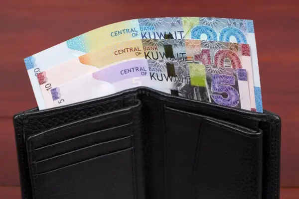 Czarny portfel z banknotami dinara kuwejckiego. Czy to najdroższa waluta świata?