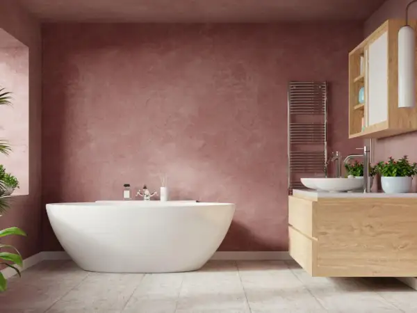 Bagno moderno con vasca bianca, mobile lavabo in legno e pareti color rosa antico. La migliore pittura per bagno crea un'atmosfera rilassante.