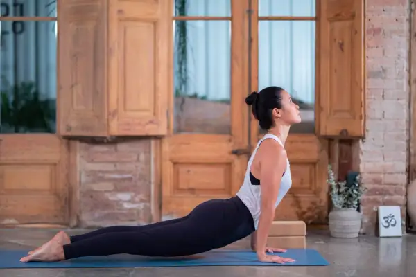 Mujer en postura de cobra, parte de un vinyasa flow yoga que es una secuencia fluida de posturas.