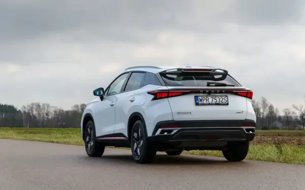 Biały, nowoczesny SUV OMODA S z charakterystycznym pasem świateł z tyłu. To jeden z nowych chińskich samochodów, który zyskuje popularność.