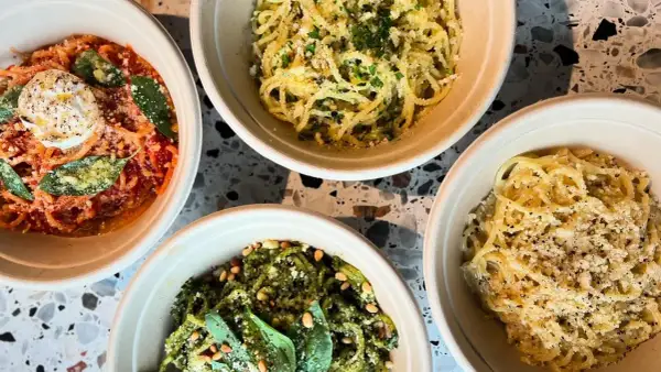 Fyra skålar med pasta, en med röd sås och burrata, en med pesto och pinjenötter, och två med ost och peppar. En hyllning till cucina povera.
