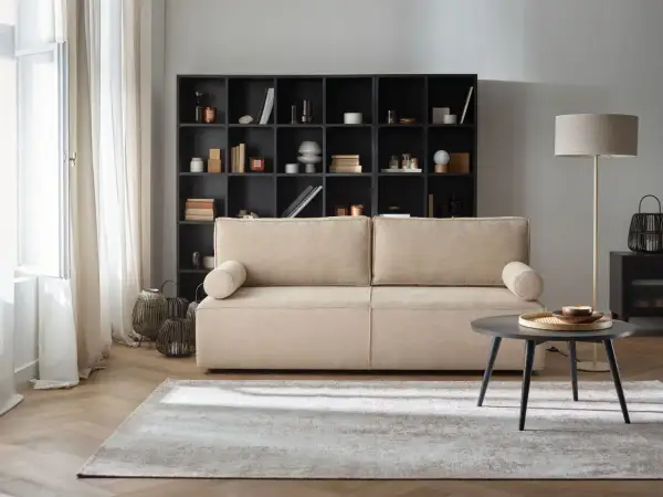 Przytulny salon z beżową kanapą i czarną biblioteczką. Gotowe aranżacje wnętrz, które inspirują do stworzenia własnej, stylowej przestrzeni.