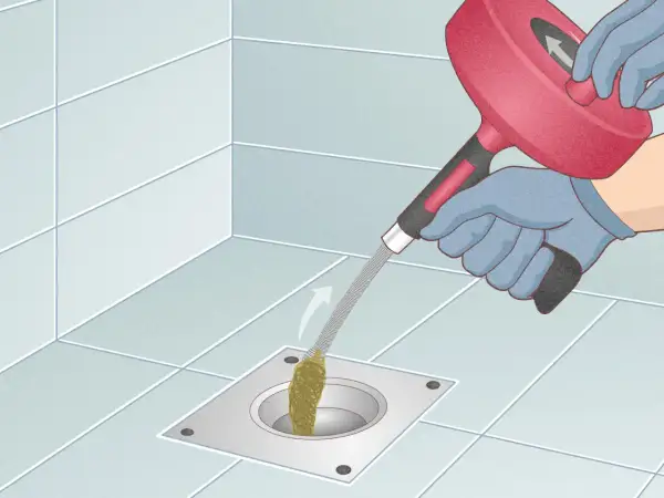 Gloves on, a drain snake is used to clear a clog from a shower drain. This shows how to snake a drain effectively.