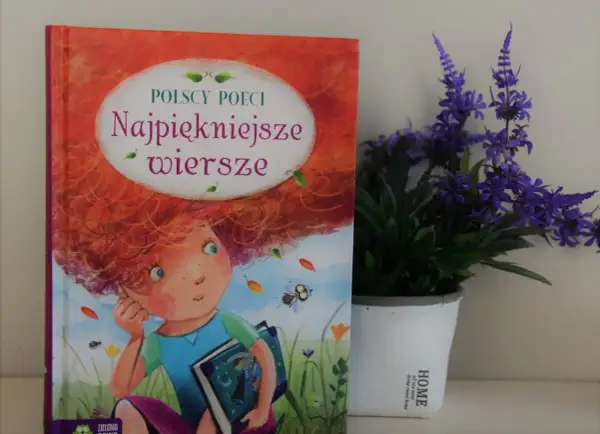 Książka "Najpiękniejsze wiersze polskich poetów" z ilustracją dziewczynki z rudymi włosami, obok doniczki z fioletowymi kwiatami.