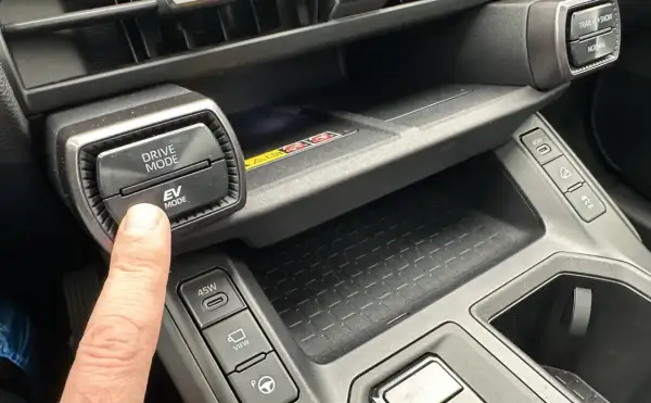 Palec naciska przycisk EV MODE na panelu Toyota. Dowiedz się, co to drive mode Toyota i jak wpływa na jazdę.