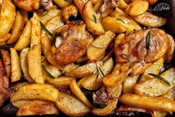 Fusi di pollo al forno con patate dorate e rosmarino, un piatto succulento e profumato, pronto per essere gustato.