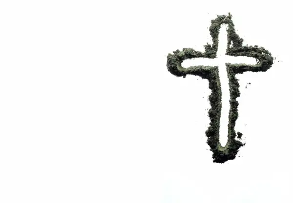 Krzyż z zielonego proszku, symbolizujący życie i wiarę, na tle pustki. Czy inseminacja może być zgodna z naukami kościoła?