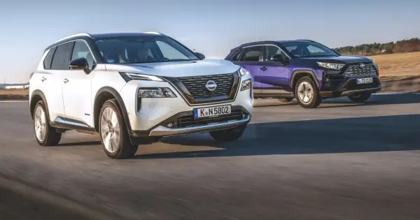 Biały Nissan X-Trail i fioletowy SUV jadą po drodze.