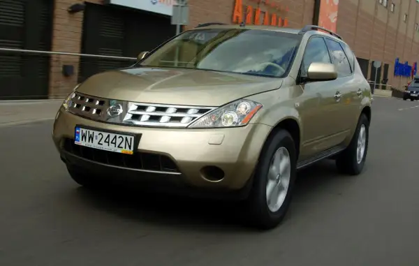 Złoty Nissan Murano 3.5 V6 w ruchu miejskim, z widocznym numerem rejestracyjnym WW 2442N.