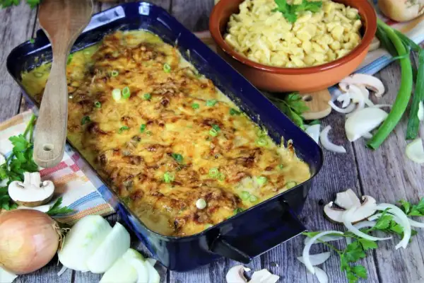 Zwiebel Sahne Schnitzel, überbacken mit Käse, daneben Spätzle, Zwiebeln und Pilze.