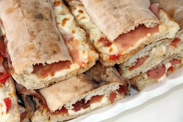 Paposcia come farcirla: focaccia ripiena di prosciutto e formaggio fuso, un'idea gustosa per un pasto veloce.