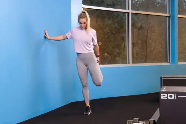 Donna esegue stretching quadricipiti, un ottimo esercizio per la gonalgia al ginocchio.