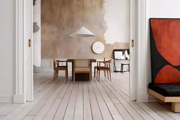 Sala da pranzo con pareti a pittura a calce grezza, tavolo in legno e sedie moderne. Un quadro astratto rosso e nero domina lo spazio.