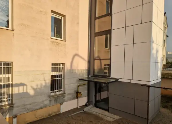 Nowoczesny blok z jasną elewacją i przeszklonym wejściem. Poznaj, jak zapisać adres mieszkania w bloku, by listonosz go odnalazł.