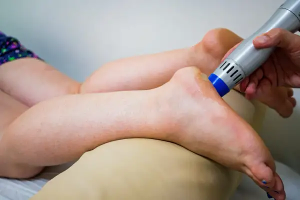 Behandlung eines Fußes mit einem Ultraschallgerät, um neurologische Ursachen für Krallenzehen zu lindern.