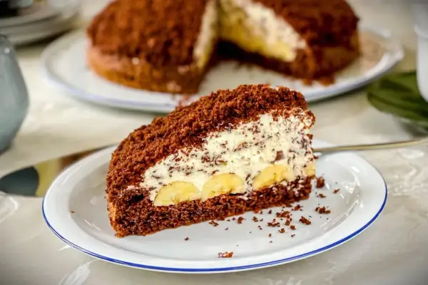 Ein Stück saftiger Maulwurfkuchen mit Bananen und Sahne. Dieses Maulwurfkuchen Rezept ist ein Genuss!