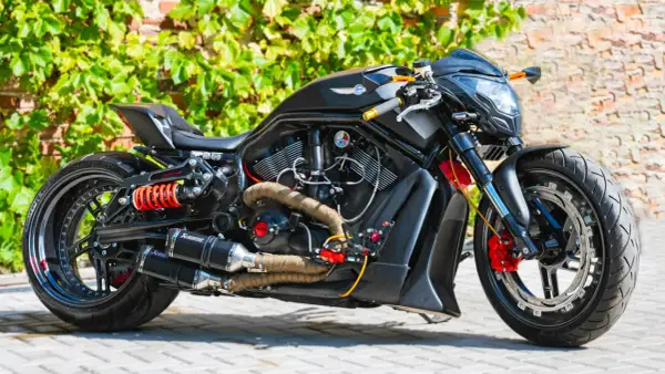 Czarny, sportowy motocykl z pomarańczowymi akcentami i podwójnym wydechem Akrapovič. Ten monowahacz to marzenie każdego fana motoryzacji.