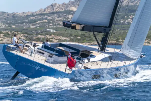 Il Solaris 74 "Luminous III" naviga con vele spiegate, solcando le onde blu. Due persone a bordo godono della brezza marina.