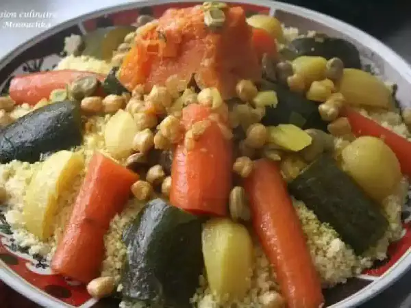 Un plat coloré de recette couscous avec carottes, courgettes, pois chiches et pommes de terre.