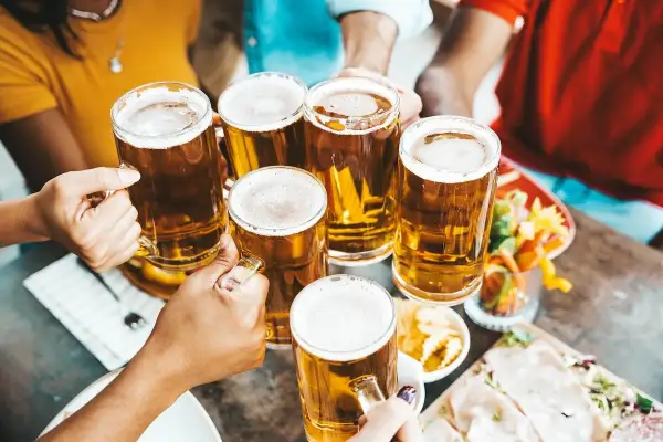 Brindisi con birra season! Amici brindano con boccali di birra dorata, un momento di gioia e condivisione.