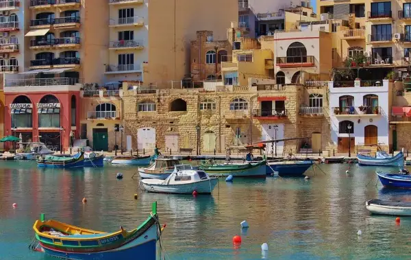 Malta, z kolorowymi łodziami i kamiennymi budynkami. Czy na Maltę potrzebny paszport? Tak, jeśli nie jesteś obywatelem UE.
